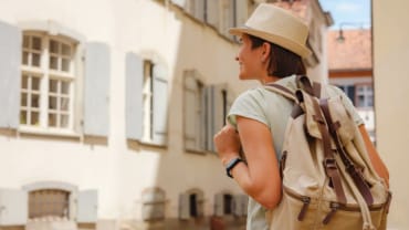 Tourisme - Femme avec sac à dos visitant une ville touristique